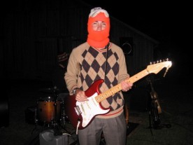 Josh Shaffer playing guitar while wearing a blaze orange balaclava
